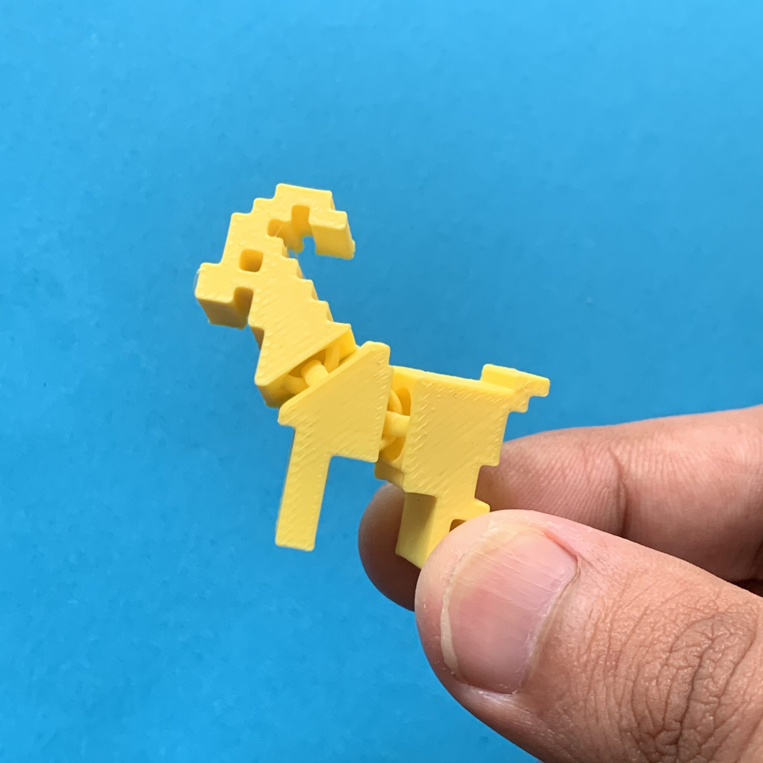 Holding 3d Printed Pixel Goat Flexi Keychain Yellow