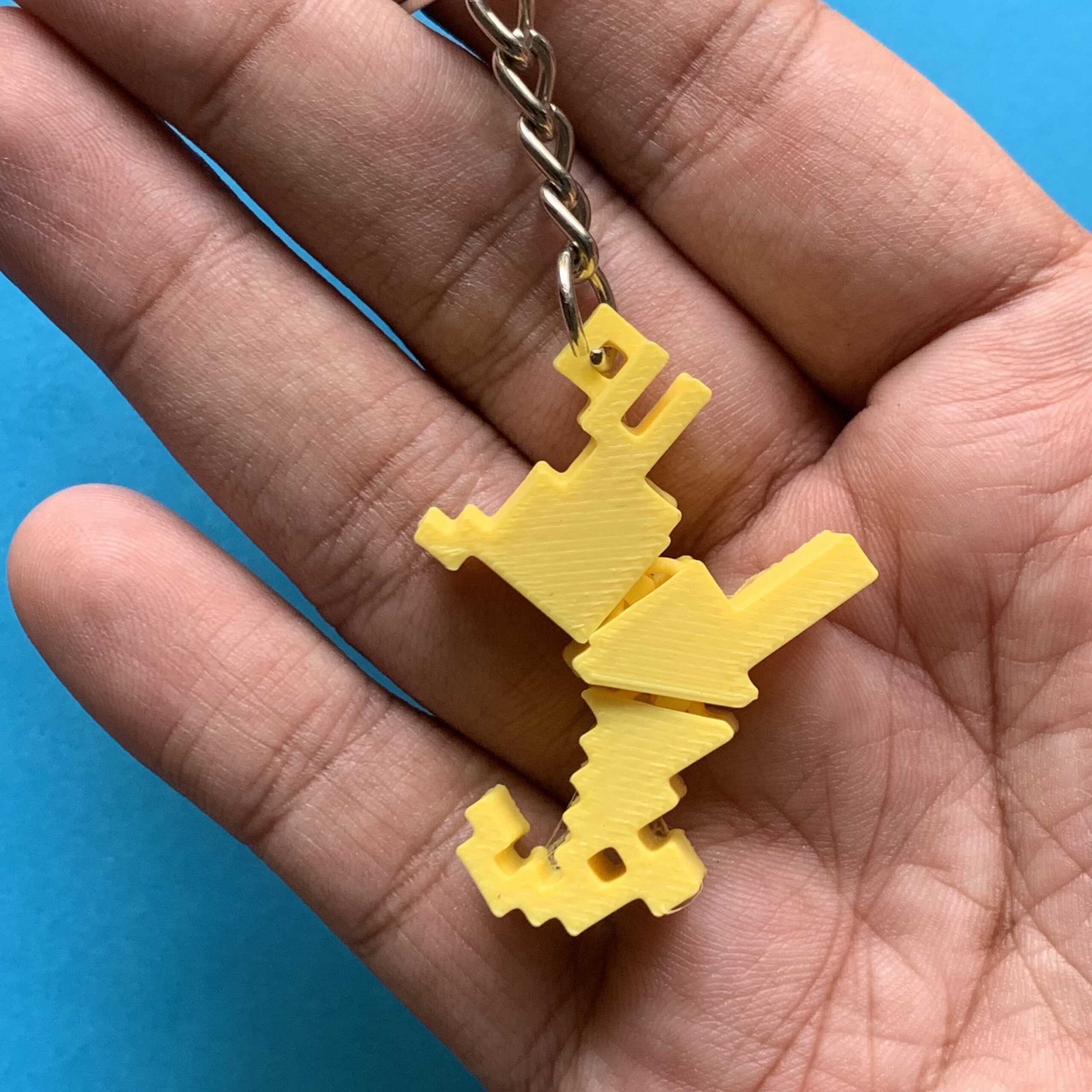Showing 3d Printed Pixel Goat Flexi Keychain Yellow on Hand