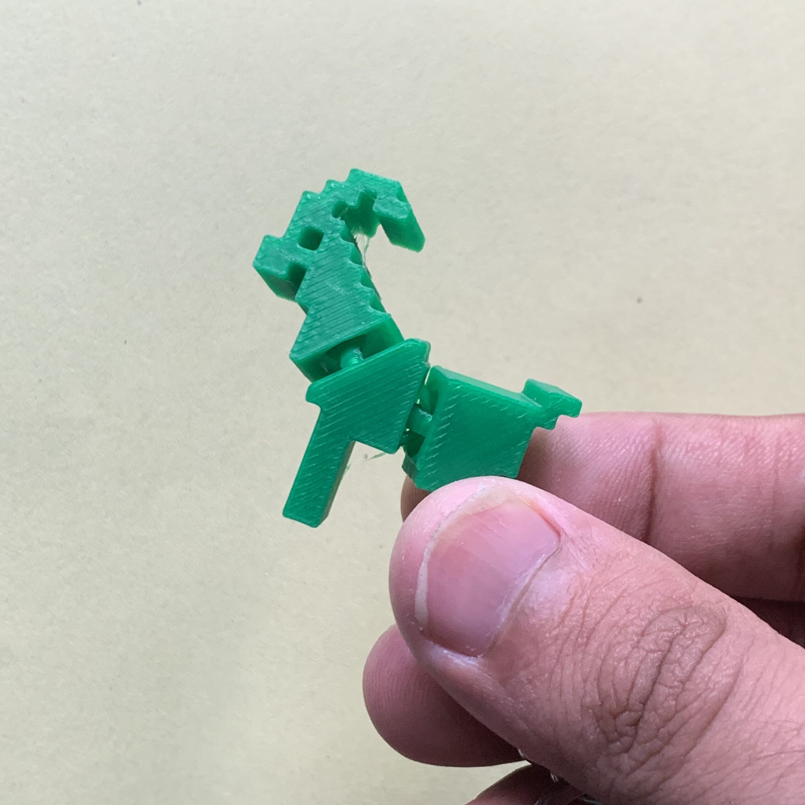 Holding 3d Printed Pixel Goat Flexi Keychain Green